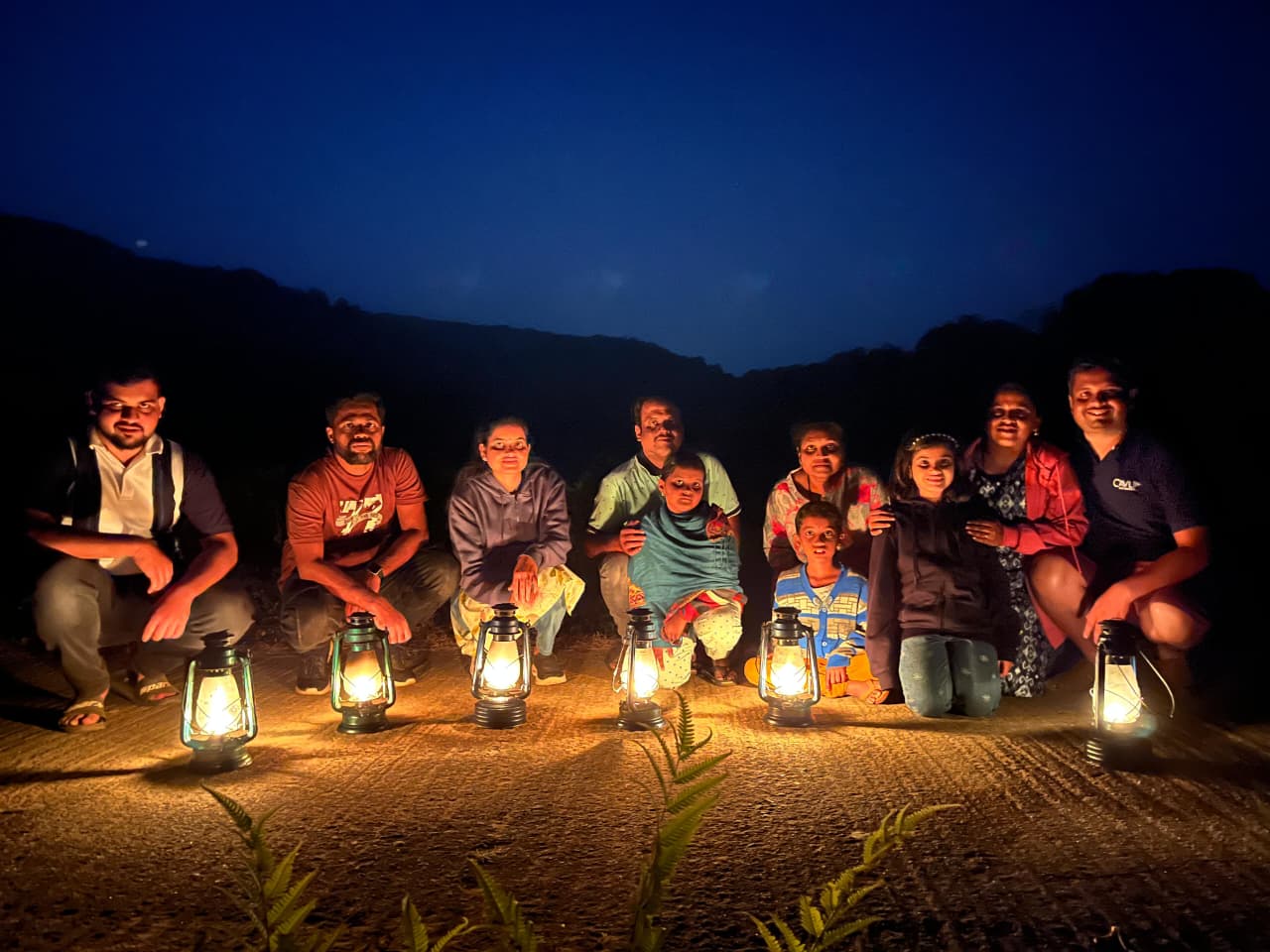 Guests walking through Coorg plantation at night with lanterns