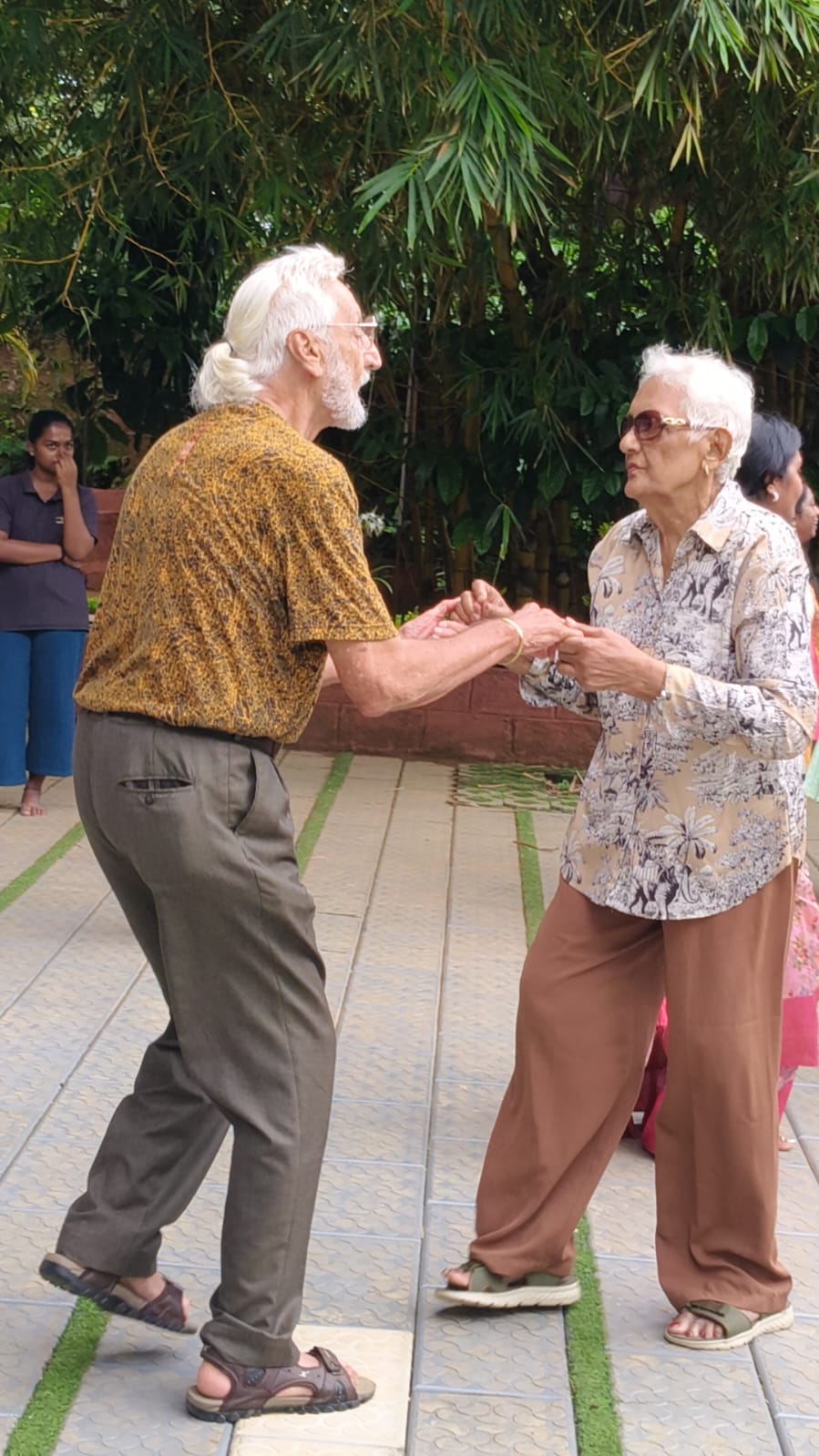 An elderly couple dancing and holding hands at Evergreen County