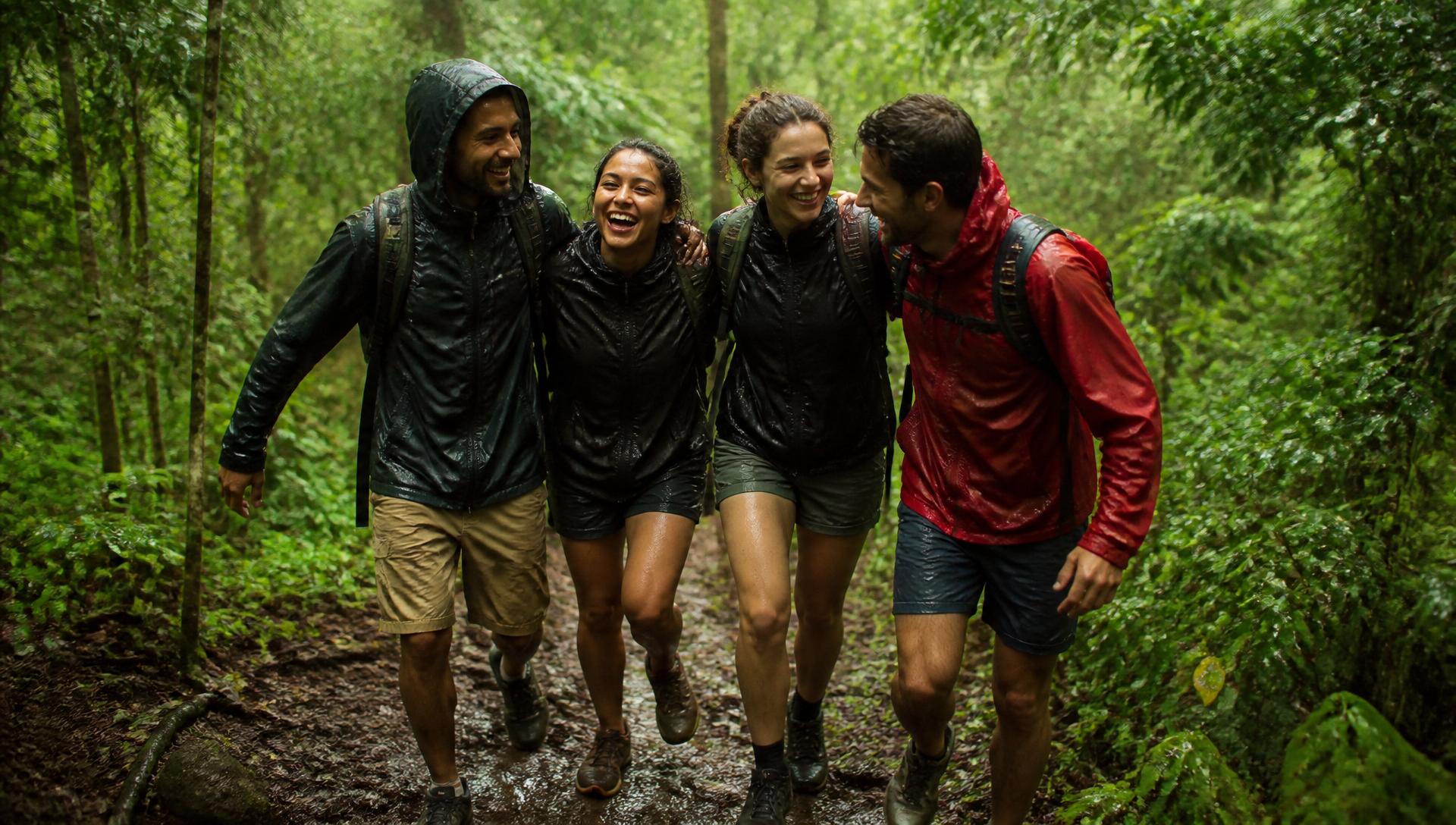 Friends laughing in the rain on a muddy forest trail