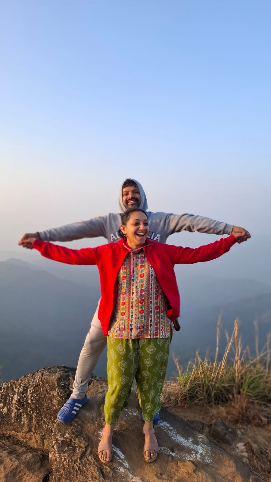 Couple on a misty hilltop after a sunrise trek